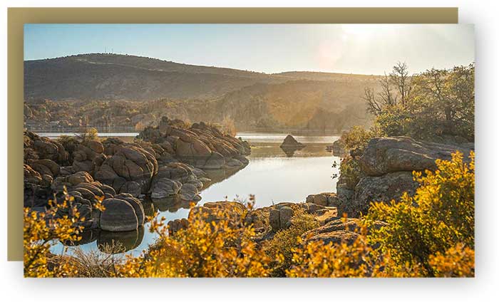 Granite rock formations surrounding lake at sunset